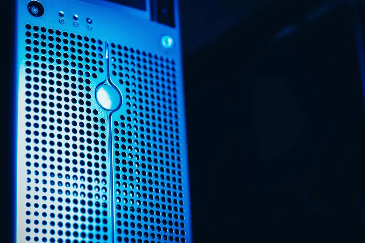 A server tower lit blue in a dark rack