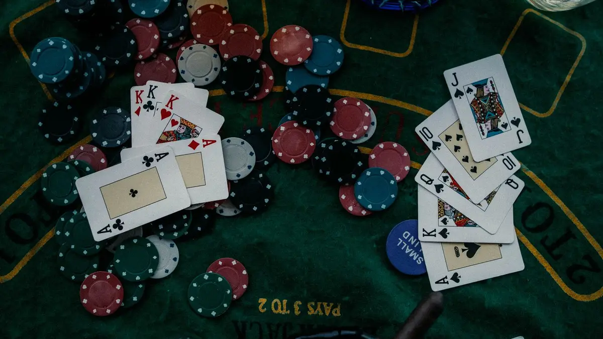 Several face-up poker hands and scattered chips across a green felt table