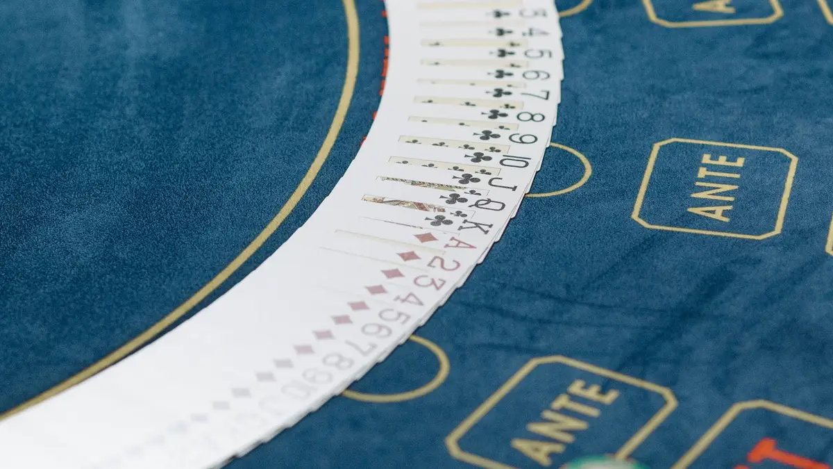 A full deck fanned in an arc across a blue felt casino table